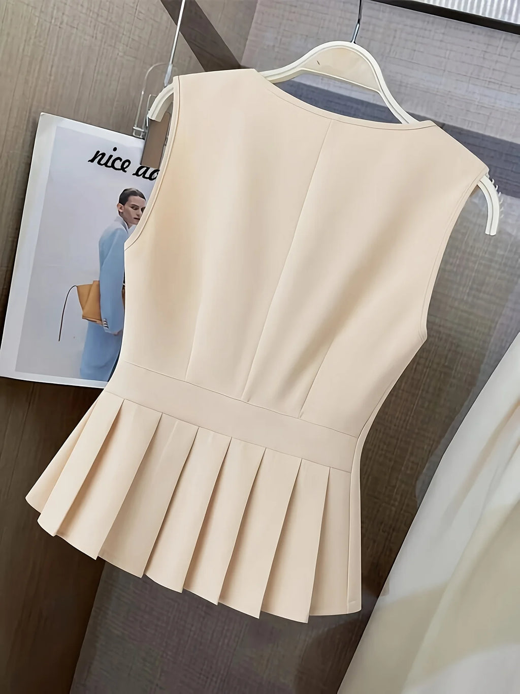 Women’s clothing featuring a V-neck, sleeveless design with pleats at the hem. Perfect for casual or professional settings with