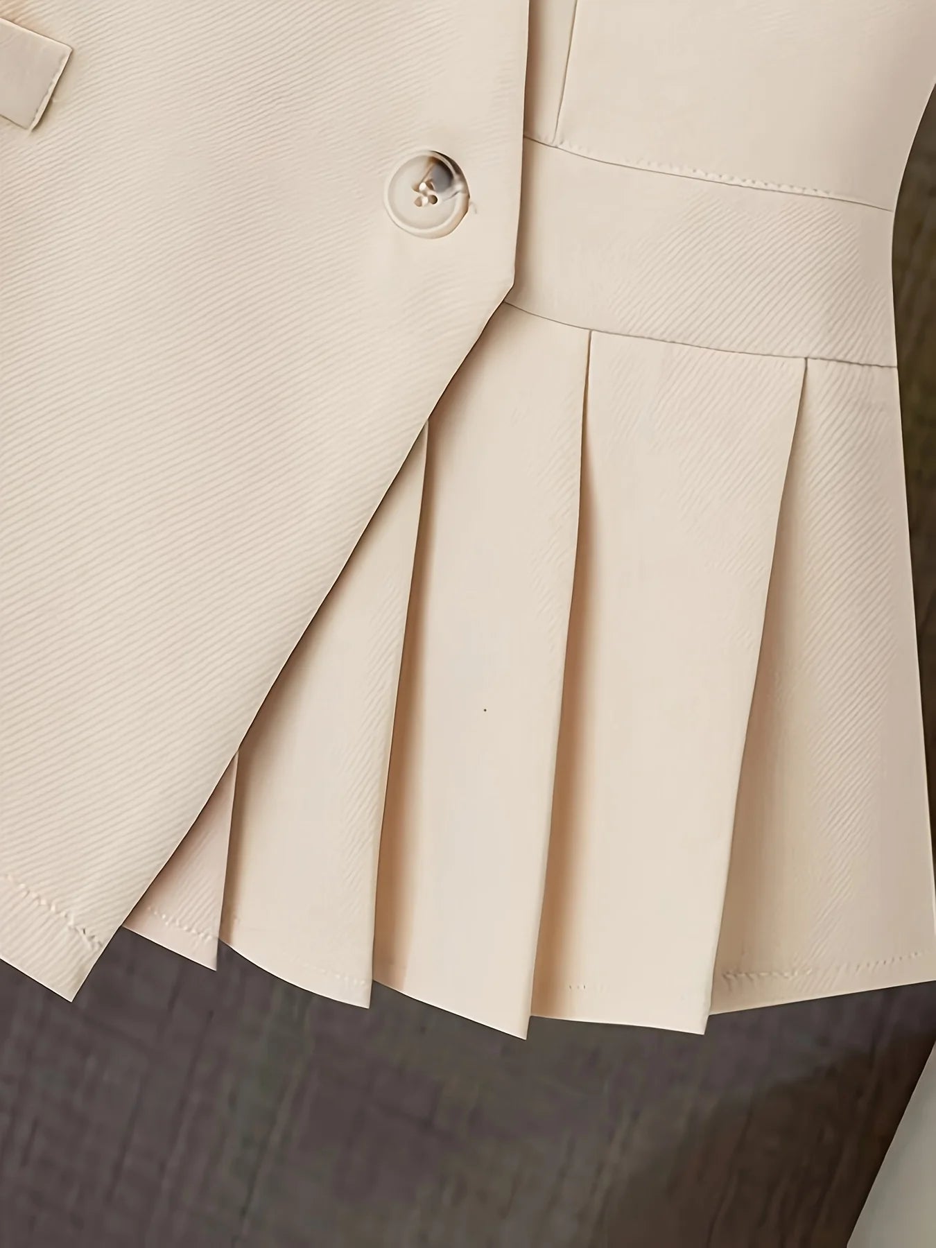 Women’s clothing featuring a V-neck, sleeveless design with pleats at the hem. Perfect for casual or professional settings with