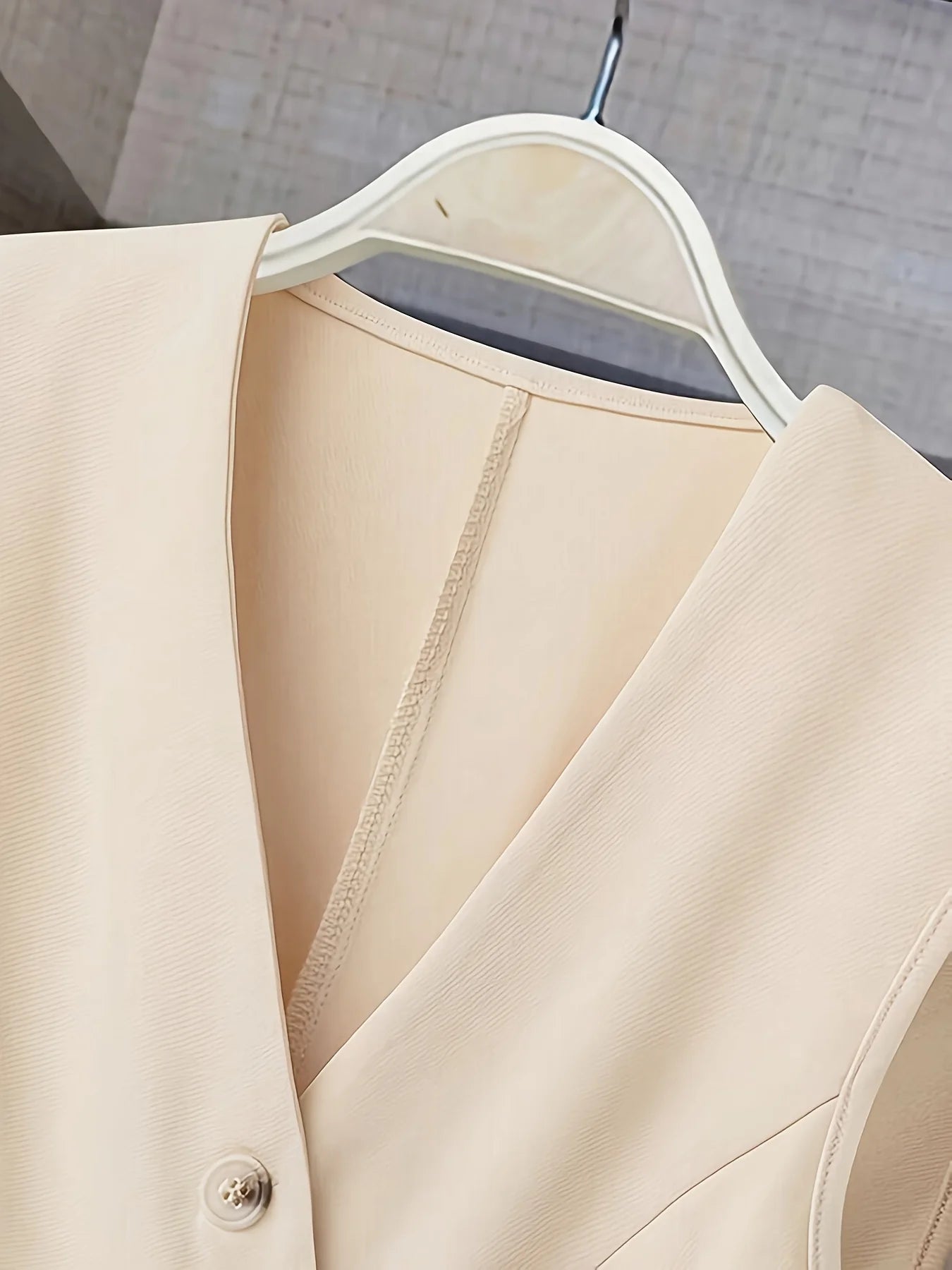 Women’s clothing featuring a V-neck, sleeveless design with pleats at the hem. Perfect for casual or professional settings with